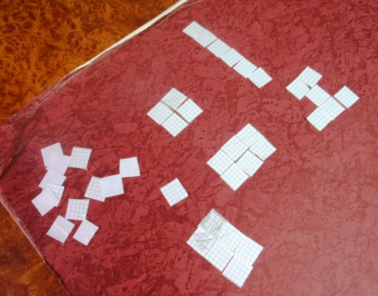 Understanding square centimeter the girls cut up pieces of graph paper in 1 cm squares and used them to create areas of different sizes and shapes/
