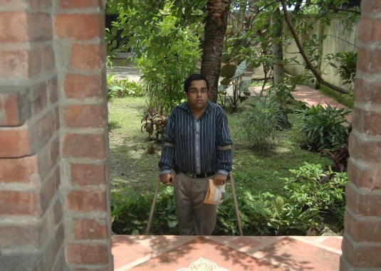Sudipendu Dutta on crutches standing outside inaccessible meditation building 